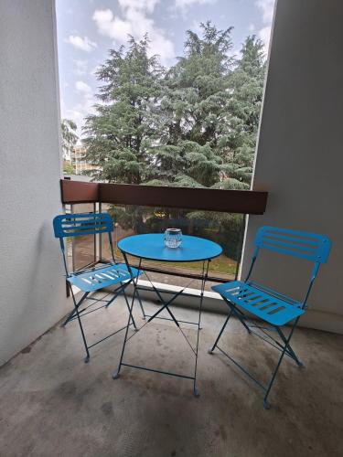 deux chaises et une table devant une fenêtre dans l'établissement Les Glières - Appartement confortable et au calme, à Annecy