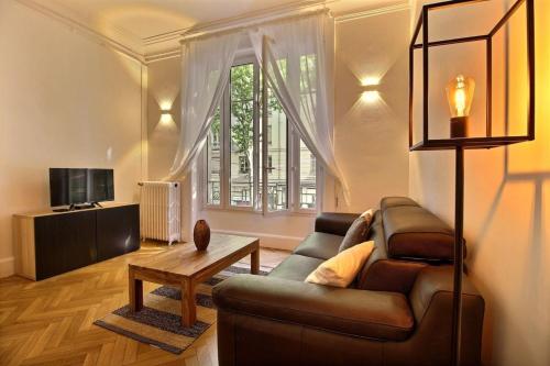 un salon avec un canapé et une table dans l'établissement Agastaïa - Monthly Rental Apartment - Lyon 7th, à Lyon
