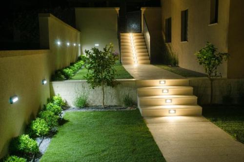 a garden with stairs leading to a house at night at SEAVIEW in Sveti Filip i Jakov
