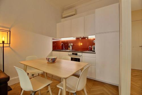 - une cuisine avec une table en bois et des chaises blanches dans l'établissement Agastaïa - Monthly Rental Apartment - Lyon 7th, à Lyon