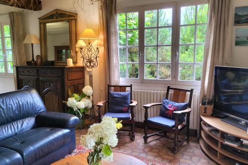 un salon avec un canapé, des chaises et une télévision dans l'établissement Beautiful villa touquettoise near the golf, à Le Touquet-Paris-Plage