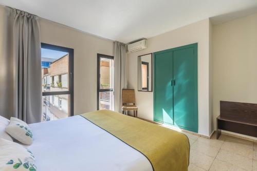 1 dormitorio con 1 cama grande y puerta verde en Itaca Colón by Soho Boutique, en Córdoba