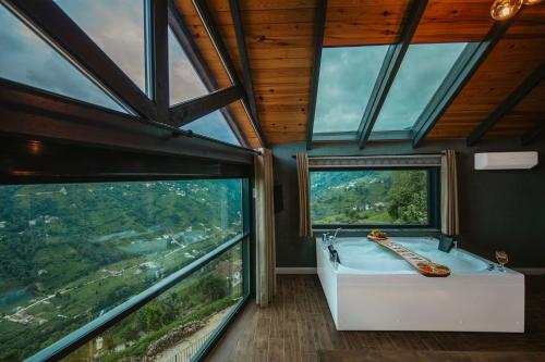 a bathroom with a tub and large windows at Lazivilla Suit Dağ Evi in Rize