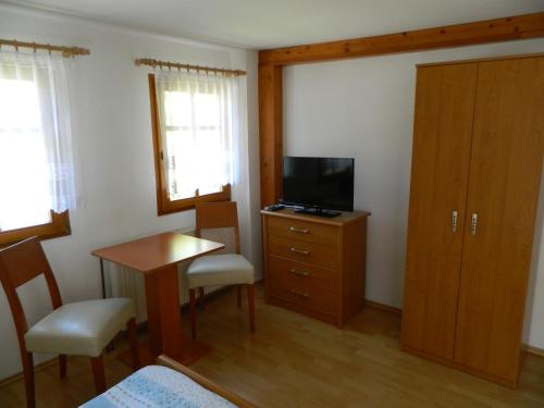 a bedroom with a desk and a television and a table at Privát Fedoriška in Špindlerův Mlýn