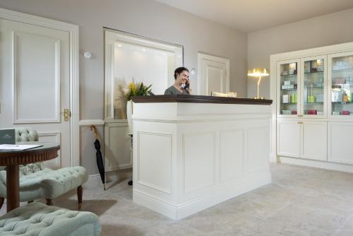 a man standing at a bar in a room at Tulfarris Hotel and Golf Resort in Blessington
