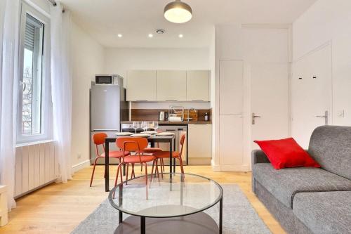 un salon avec un canapé et une table avec des chaises dans l'établissement Montgolfier 5 - T2 apartment with garage in a residence - Villeurbanne, à Villeurbanne