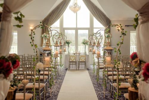a wedding aisle in a room with chairs at Tulfarris Hotel and Golf Resort in Blessington