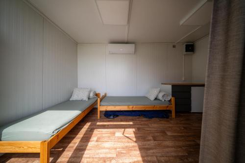 a room with two beds and a table at BoardHouse Spot in Svencelė