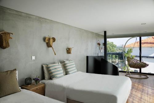a bedroom with two beds and a large window at L'École Eco Resort in Água Travessa