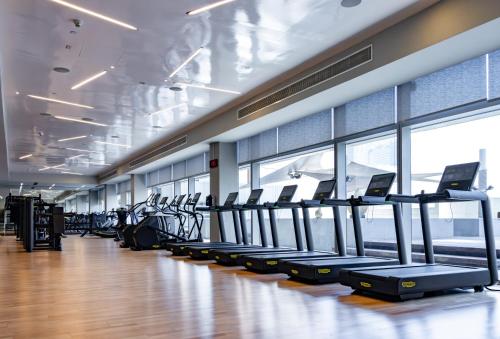 a gym with rows of treadmills and elliptical machines at Conrad Dubai in Dubai