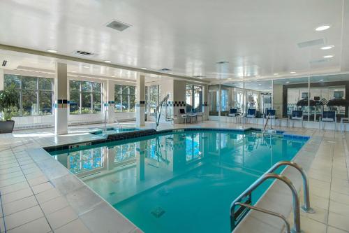 a large swimming pool with blue water in a building at Hilton Garden Inn Detroit Metro Airport in Romulus