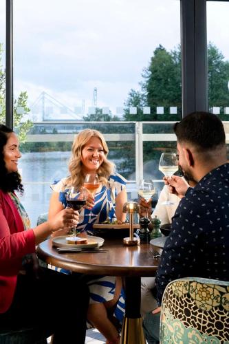 a group of people sitting around a table with wine glasses at Hilton Birmingham Metropole Hotel in Bickenhill