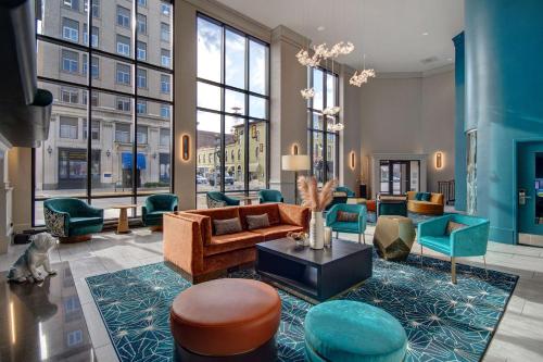 a living room with furniture and a large window at Hilton Garden Inn Terre Haute in Terre Haute