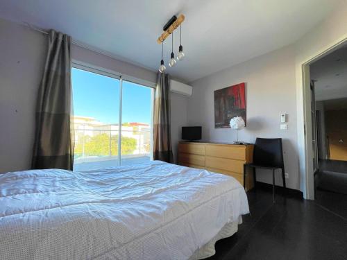 une chambre avec un lit et une grande fenêtre dans l'établissement Villa Moderne à Sète: Piscine Privée, Plage à 200m, Clim, WIFI - FR-1-338-334, à Sète