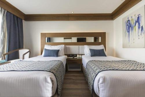 a hotel room with two beds and a desk at Sofia Nile Cruise Luxor & Aswan in Luxor