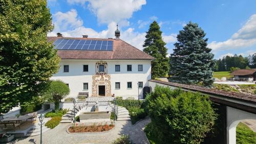a white house with solar panels on the roof at Room in a Farm Residence Austria - Shared bathroom in Iglbach