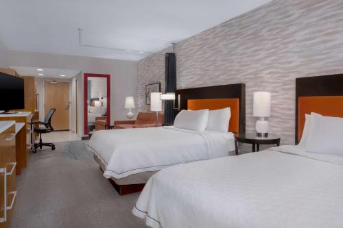 a hotel room with two beds and a desk at Home2 Suites By Hilton Gainesville in Gainesville