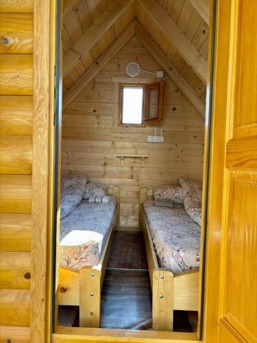 a bedroom with two beds in a log cabin at Camp Mrdak Lipovo in Kolašin