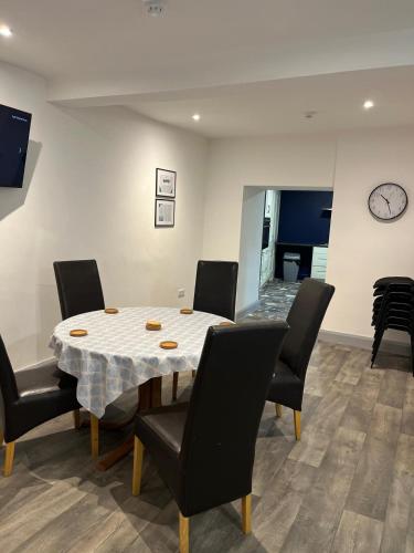 a dining room with a table and chairs and a clock at 'James Lyons' The old main St in Ballyhaunis