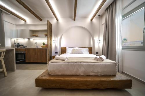a bedroom with a large bed and a kitchen at Αnasa by the sea in Agia Pelagia
