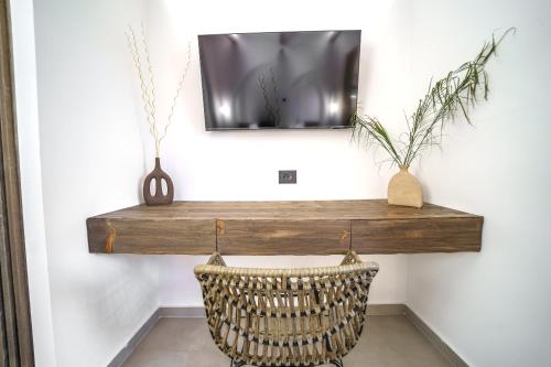 a television hanging on a wall with a wicker basket at Αnasa by the sea in Agia Pelagia