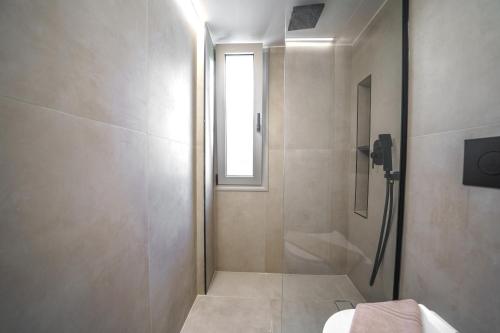 a bathroom with a shower and a toilet and a window at Αnasa by the sea in Agia Pelagia