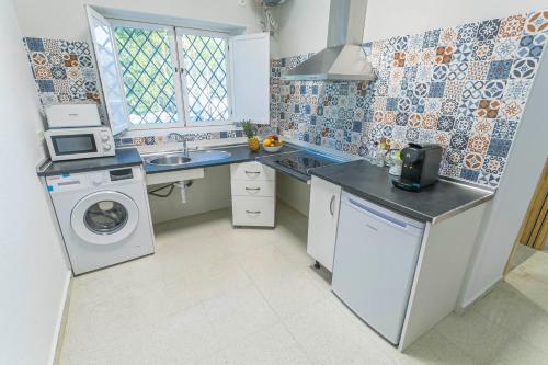 a kitchen with a sink and a washing machine at Embrujo Andaluz Complejo Rural Órgiva in Órgiva
