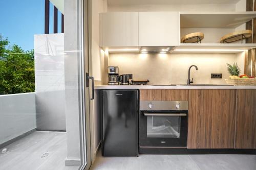 a kitchen with a black refrigerator and a sink at Αnasa by the sea in Agia Pelagia