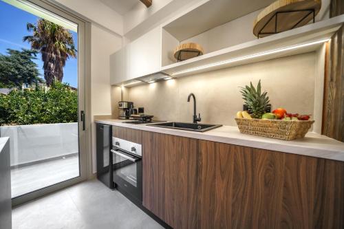 a kitchen with a sink and a bowl of fruit at Αnasa by the sea in Agia Pelagia