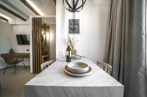 a dining room with a table with a bottle of wine at Αnasa by the sea in Agia Pelagia