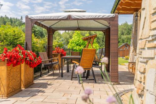 a gazebo with a table and chairs under it at DW Bogun in Białka Tatrzanska