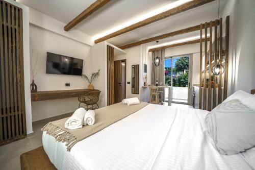 a bedroom with a large white bed with towels on it at Αnasa by the sea in Agia Pelagia