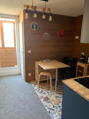une cuisine avec une table et une table et une fenêtre dans l'établissement Appartement moderne 4 pers Idéalement situé, à Huez