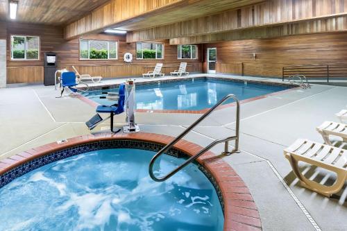 a large pool with a hot tub in a building at Comfort Suites Portland Airport in Portland