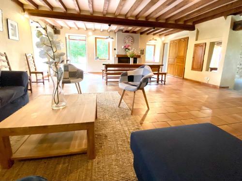 un salon avec un canapé et une table dans l'établissement Gîte écologique de charme avec grand jardin, proche des Alpes Mancelles, idéal famille et amis - FR-1-410-132, à Moulins-le-Carbonnel