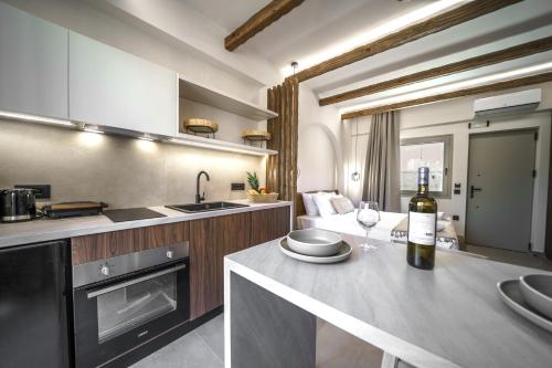 a kitchen with a table with a bottle of wine at Αnasa by the sea in Agia Pelagia
