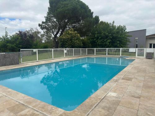 a large blue swimming pool with a white fence at ibis Cahors in Cahors