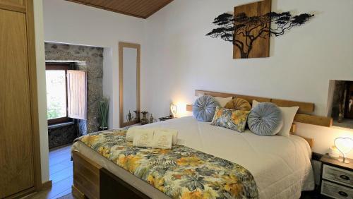 a bedroom with a large bed with pillows on it at Casa do Penedo Castle House in Linhares