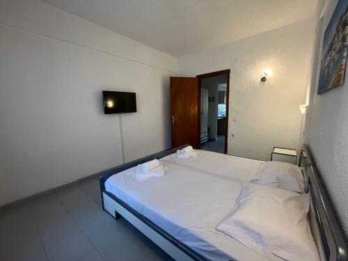 a bedroom with a large bed with white sheets at Sirtaki-Siviri Apartments in Siviri