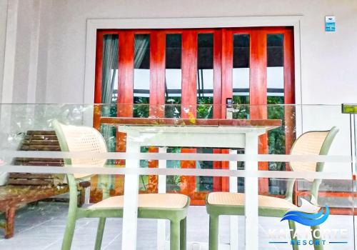 a table and chairs in front of a window at Kata Forte Resort in Kata Beach