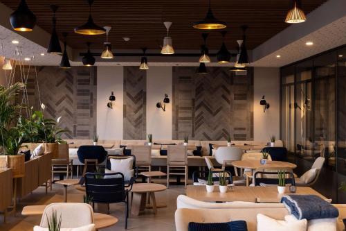 a restaurant with tables and chairs and a cafeteria at Hilton Garden Inn Le Havre Centre in Le Havre