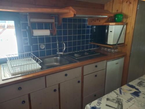 une cuisine avec un évier et un plan de travail dans l'établissement Roulotte au pied du Mont Saint Michel, à Pontorson
