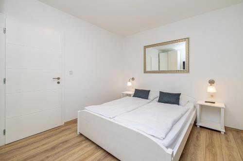 a white bedroom with a white bed and a mirror at Villa Haya with heated pool in Linardići