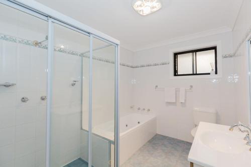 Un baño con ducha de cristal y lavabo. en 4-1 Penders Court, en Jindabyne