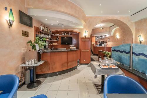 a restaurant with a bar and blue chairs at Hotel Italia in Trieste