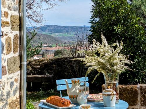 une table avec un vase de fleurs et de pain sur elle dans l'établissement Cabane de Vigne en Auvergne pour Escapade Romantique - FR-1-582-74, à Langeac