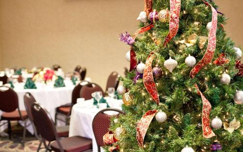 a christmas tree in the middle of a room with tables at Radisson Hotel Corning in Corning