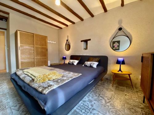 une chambre avec un grand lit dans une pièce dans l'établissement Gîte charmant proche du Mans et de la Flèche, tout confort, jardin clos, garage, animaux bienvenus - FR-1-410-313, à Courcelles-la-Forêt