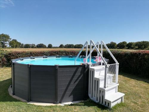 une piscine avec un escalier menant à celle-ci dans l'établissement Gîte en campagne rénové avec cheminée, grands jardins, WiFi, près d'un village médiéval. - FR-1-410-334, à Moitron-sur-Sarthe