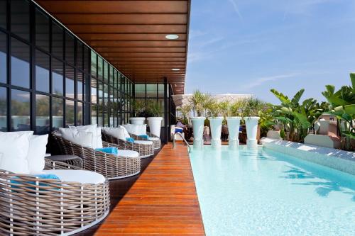 a hotel with a swimming pool with wicker chairs at Monument Hotel in Barcelona